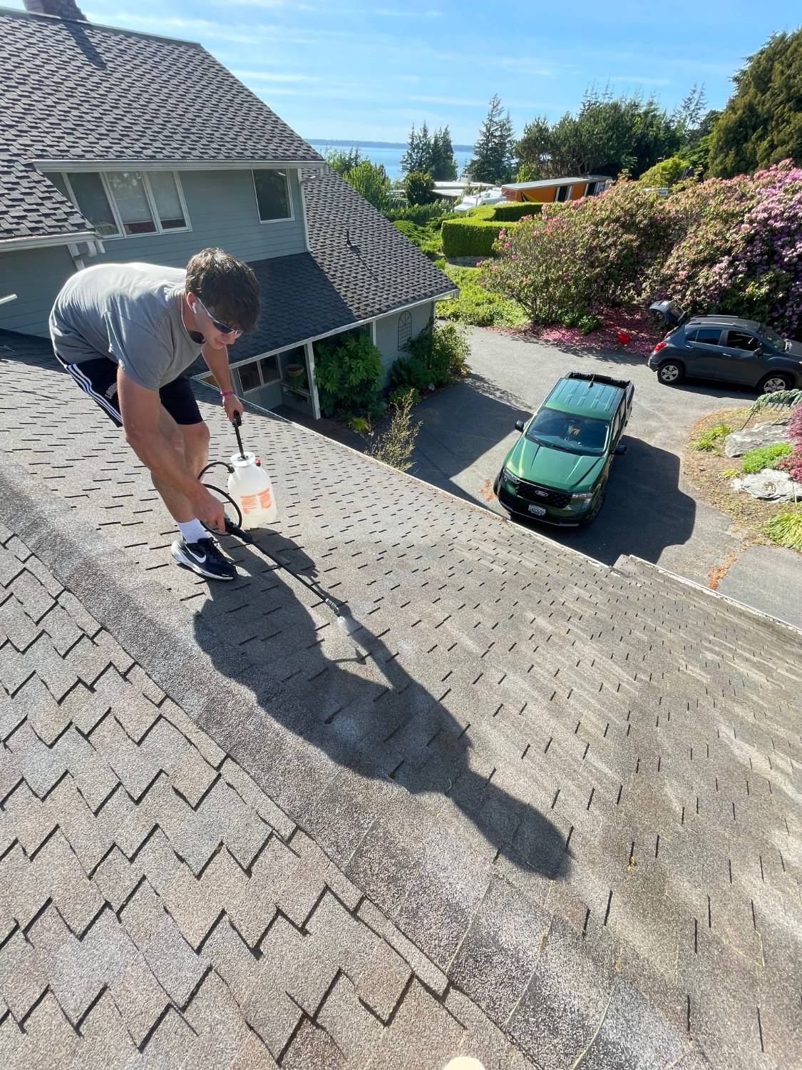 Property Bros technician treating a shingle roof for moss in Whidbey Island WA